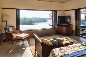 a living room with a bed and a large window at Cape Weligama in Weligama