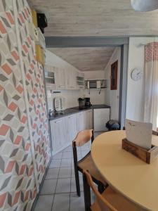 a kitchen with a table and a table and chairs at Chanteduc in Beaurières