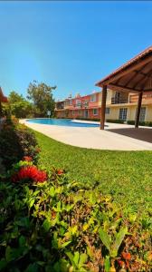 a green yard with flowers in front of a building at Casa Morroken Ixtapa con Alberca in Ixtapa