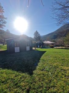 a house in a field with the sun behind it at Chanteduc in Beaurières +1 photo