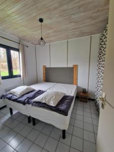 a bedroom with a white bed with a wooden ceiling at Chanteduc in Beaurières