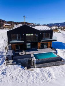 a house with a swimming pool in the snow at Nordic Star Chalet in Fundata