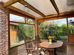 a patio with a table and two chairs and a table at Bungalow Marita in Julianadorp +10 photos