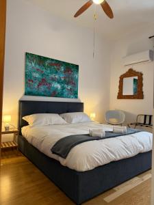 a bedroom with a large bed with a painting above it at I Maltesi apartment in Sassari