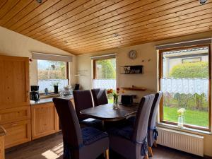 a kitchen and dining room with a table and chairs at Bungalow Marita in Julianadorp
