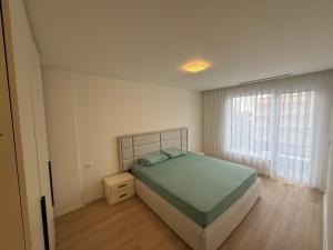 a bedroom with a bed and a large window at OMA Residence in Ferizaj