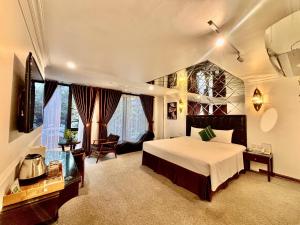 a large bedroom with a bed and a chair in it at Dinh Ami Hanoi Hotel in Hanoi +34 photos
