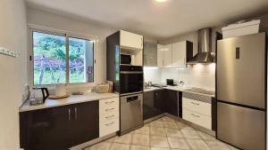 a kitchen with black and white appliances and a window at Casa Palmeiras, Seixal , Madeira in Seixal