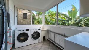 a laundry room with a washing machine and windows at Casa Palmeiras, Seixal , Madeira in Seixal