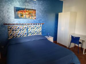 a blue bedroom with a bed and a blue wall at A due passi dal mare in Capo dʼOrlando +18 photos
