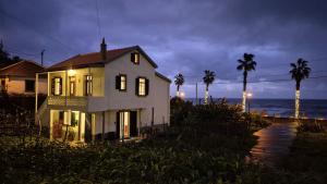 a white house with palm trees and the ocean at Casa Palmeiras, Seixal , Madeira in Seixal