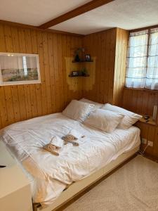 ein großes Bett in einem Zimmer mit Holzwänden in der Unterkunft Studio Idylle in Ringgenberg + 3 Fotos