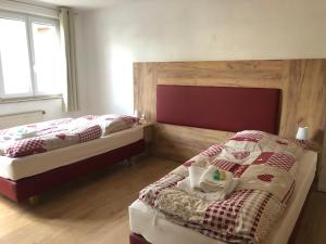 a bedroom with two beds and a wooden headboard at Gästehaus AlbTraum in Reutti