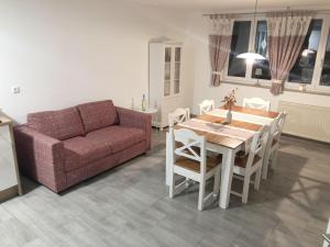 a living room with a couch and a table and chairs at Gästehaus AlbTraum in Reutti