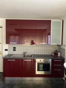 a kitchen with red cabinets and a sink at Casa Sole in Fenis