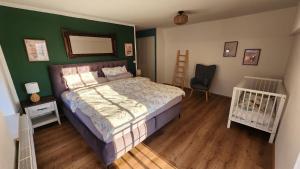 a bedroom with a bed and a green wall at Landhaus Quatitz in Großdubrau