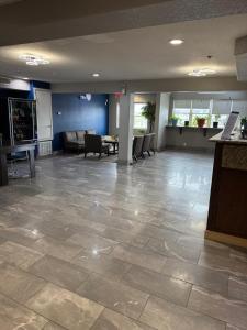 a large lobby with a waiting area with chairs and tables at Microtel Inn & Suites by Wyndham Ardmore in Ardmore