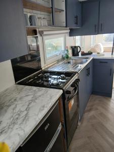 a kitchen with a stove and a counter top at Family friendly static in Pwllheli +2 photos