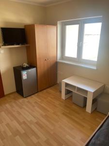 a room with a bench and a cabinet and a television at U Karola in Darłowo