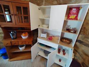 a kitchen with white shelves and a wooden cabinet at refuxio de pambre in Palas de Rei +3 photos