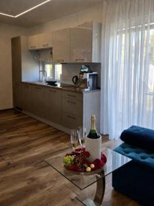 a living room with a glass table with wine glasses at Žolynų namai in Klaipėda