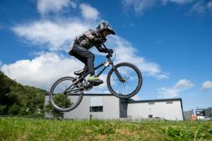 a man doing a trick on a bike in the air at Adventure Parc in Dolgarrog