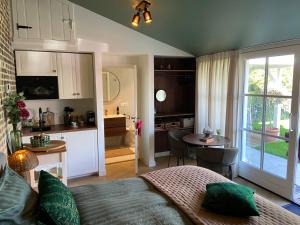 a bedroom with a bed and a kitchen with a table at Gastenverblijf Het Groene Hart in Lanaken
