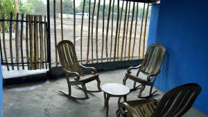 three chairs and a table in front of a window at Habitaciones Lala in Las Peñitas