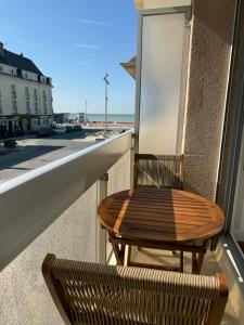 a table and chair on a balcony with a view of the ocean at Studio Ti’Sable 50m de la plage in Fort-Mahon-Plage