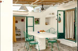 a dining room with a white table and chairs at Trulli di Ivana in Ostuni