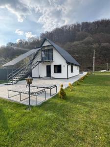 a white building with a tennis court in a field at Вича апартаменти in Sasivka