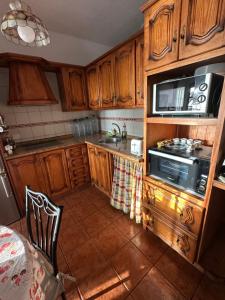 a kitchen with wooden cabinets and a sink and a microwave at Tijarafe 2 in Tijarafe