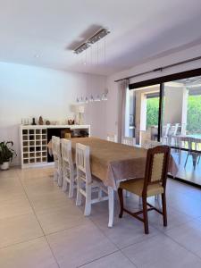 a kitchen and dining room with a table and chairs at Casa con piscina en Estancias del Pilar, 3 dormitorios, jardín y parrilla in Pilar