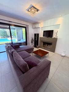 a living room with a couch and a fireplace at Casa con piscina en Estancias del Pilar, 3 dormitorios, jardín y parrilla in Pilar