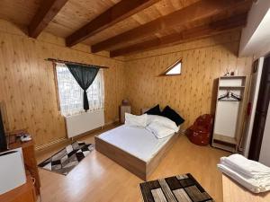 a bedroom with a bed in a wooden room at Plaiul Carpatin in Fundăţica