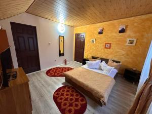 a bedroom with a large bed and a door at Plaiul Carpatin in Fundăţica +2 photos