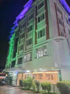 a large building with a lit up facade at night at Amala's Residency in Trivandrum
