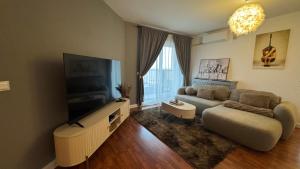 ein Wohnzimmer mit Sofa und Flachbildfernseher in der Unterkunft Arena Royal Suite in Bacău