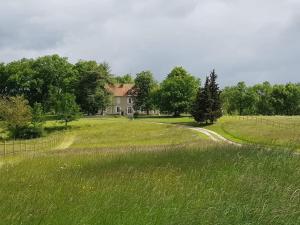 a field of grass with a house in the background at Domaine et Manoir du Picaud in Monestier