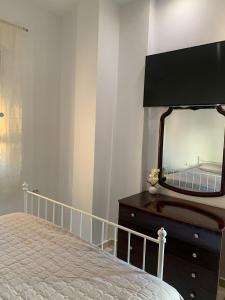 a bedroom with a dresser with a mirror on it at Golem Central Stay in Golem +3 photos