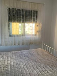 a bedroom with a bed and a window with curtains at Golem Central Stay in Golem