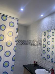a bathroom with a sink and a shower curtain at Golem Central Stay in Golem