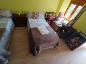 a bedroom with two beds and a fire place at refuxio de pambre in Palas de Rei