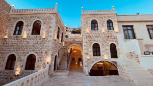 a large stone building with a staircase in front at Mara Loya Konağı in Mardin