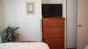a bedroom with a dresser with a television on it at The Sunset Hideaway in Cape May