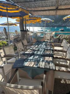 a long table with chairs and umbrellas on the beach at Villa Lyla in Capri +16 photos
