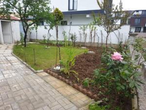 a garden with a pink rose and some trees at Yazlık in Yukarı Kocaali