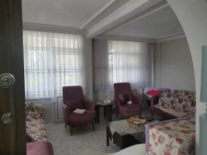 a living room with a bed and a couch and chairs at Yazlık in Yukarı Kocaali