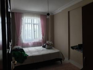 a small bedroom with a bed with a window at Yazlık in Yukarı Kocaali