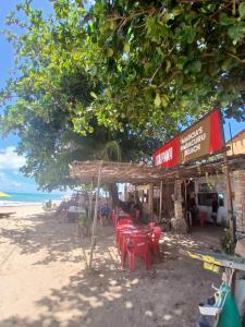 a restaurant with red tables and chairs on the beach at Pé na praia - Barraca da Márcia in Paracuru